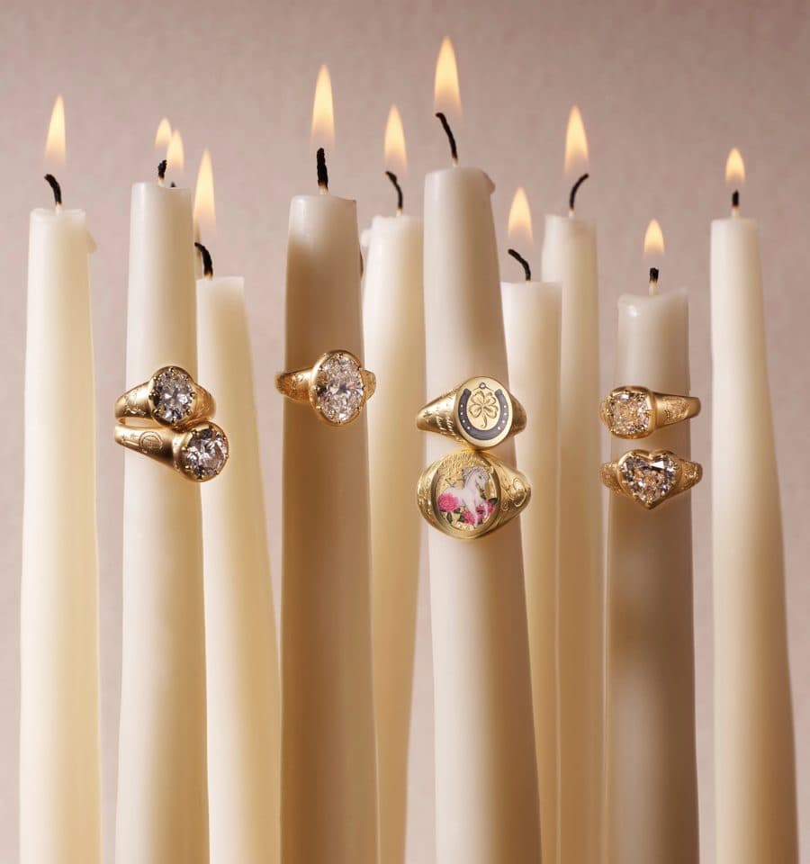 Cece gold rings set among lit ivory candles