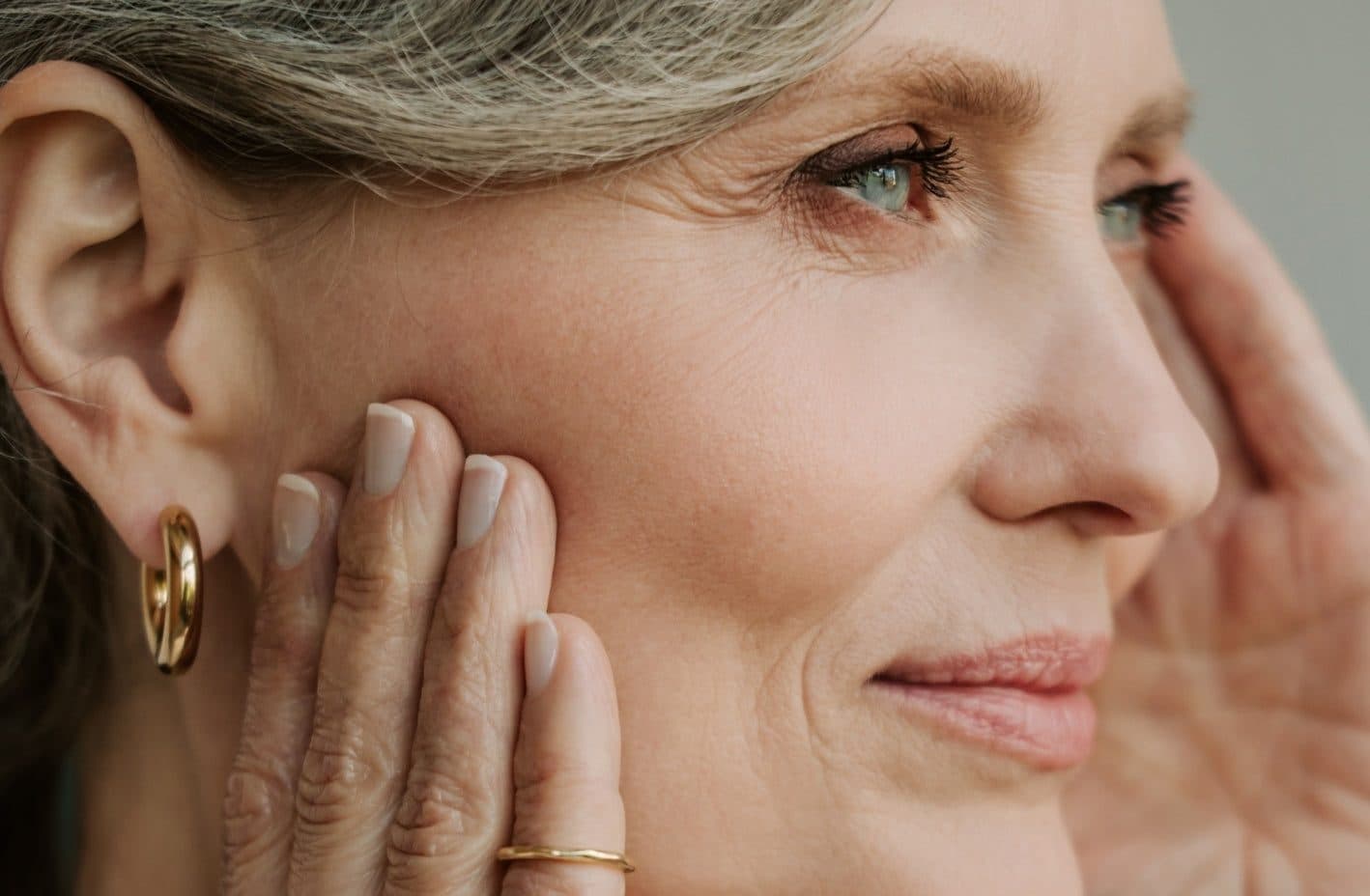 Close-up of a woman in midlife touching her cheek
